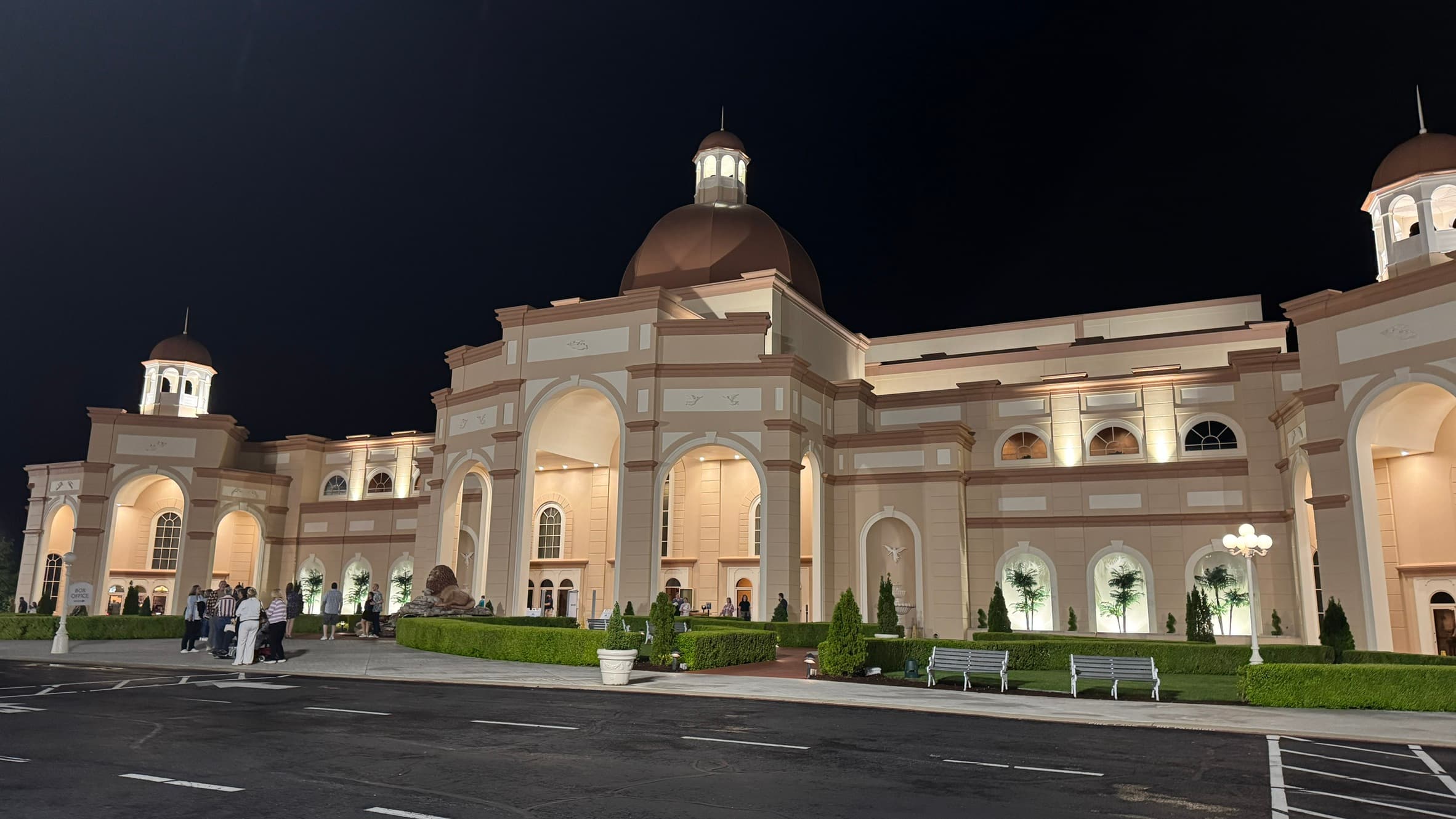 The illuminated exterior of Sight & Sound Theatre in Branson with visitors arriving for a performance