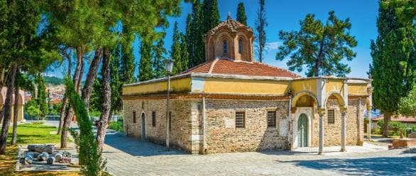 A small historic church surrounded by trees in northern Greece