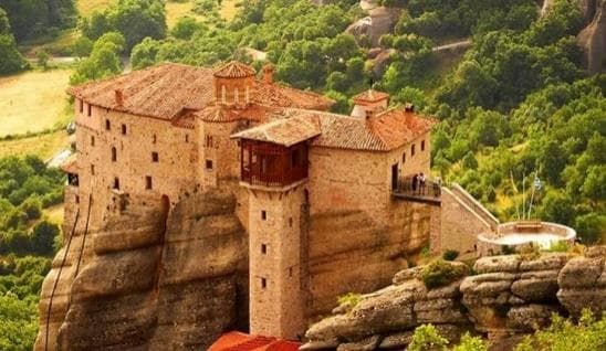 A red-roofed monastery built on a sandstone pillar at Meteora