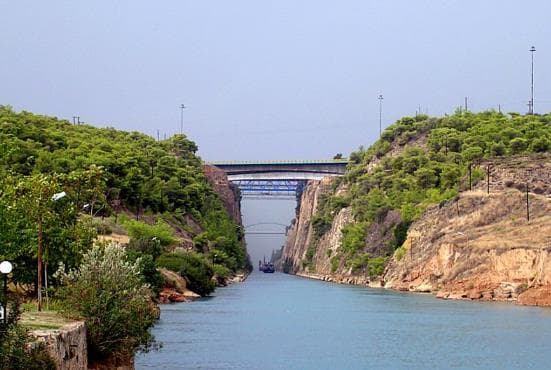 Blue water running between the steep rock walls of the Corinth Canal
