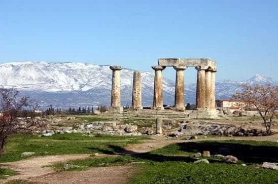 Standing columns of the Temple of Apollo at Ancient Corinth with mountains beyond