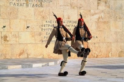 Evzone guards marching in ceremonial dress in Syntagma Square