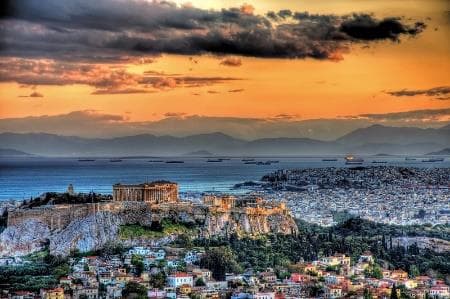 The Acropolis above Athens at sunset beneath dramatic clouds