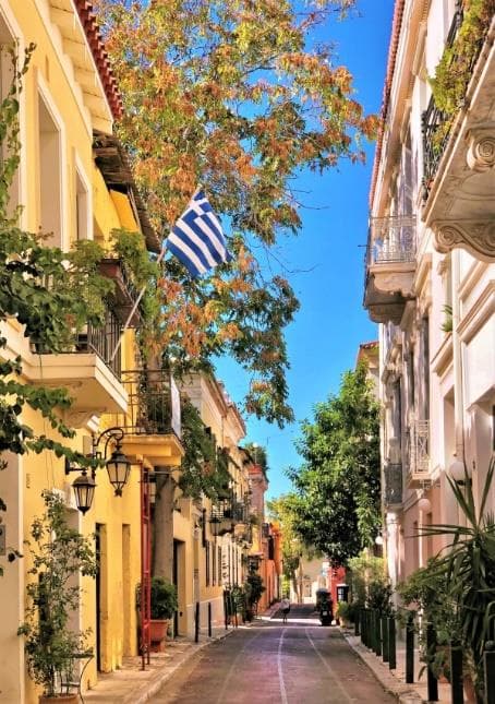 A quiet pedestrian lane lined with trees and historic buildings in Athens