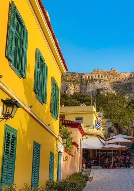 A yellow house with green shutters below the Acropolis in Athens