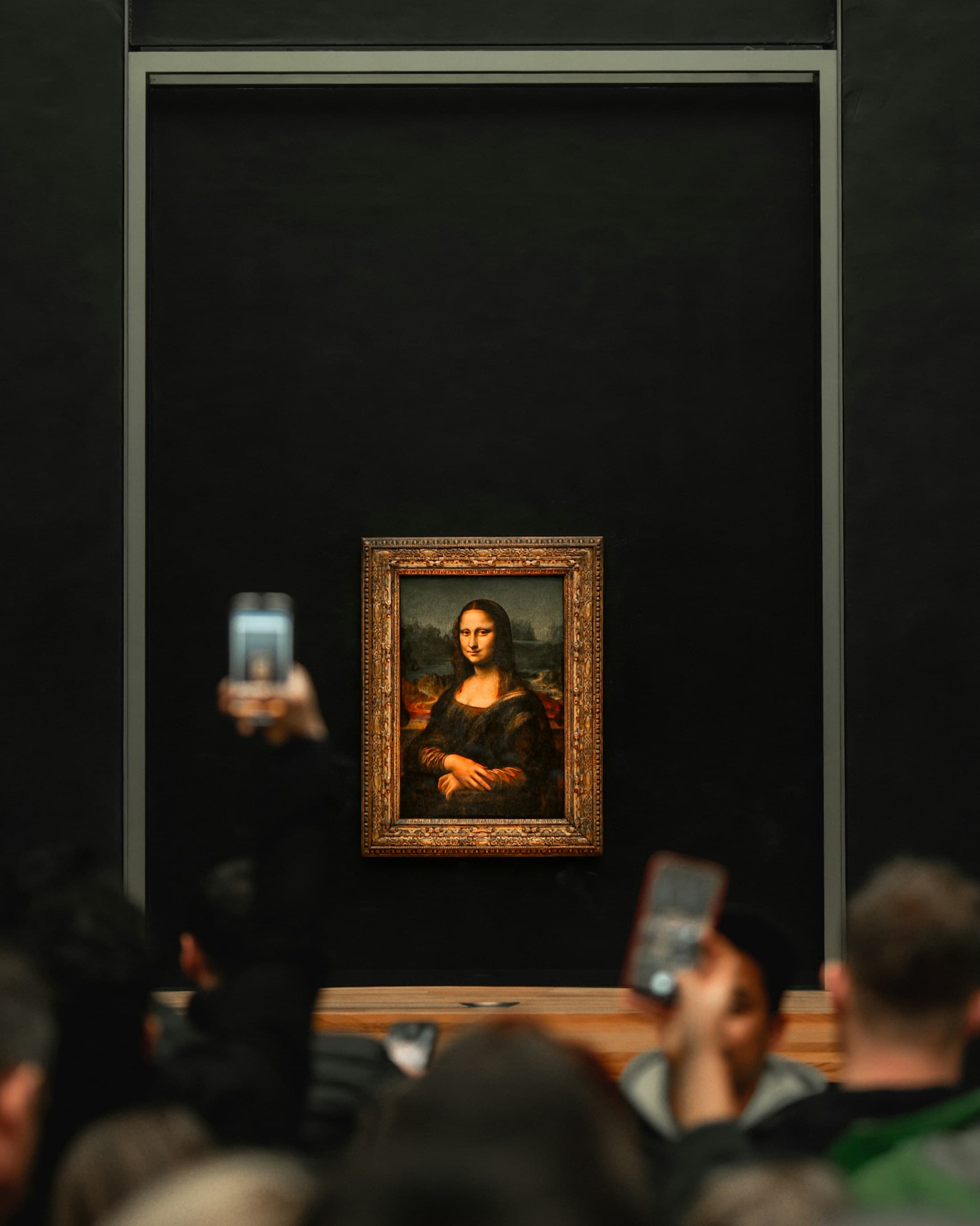 Visitors viewing the Mona Lisa inside the Louvre Museum