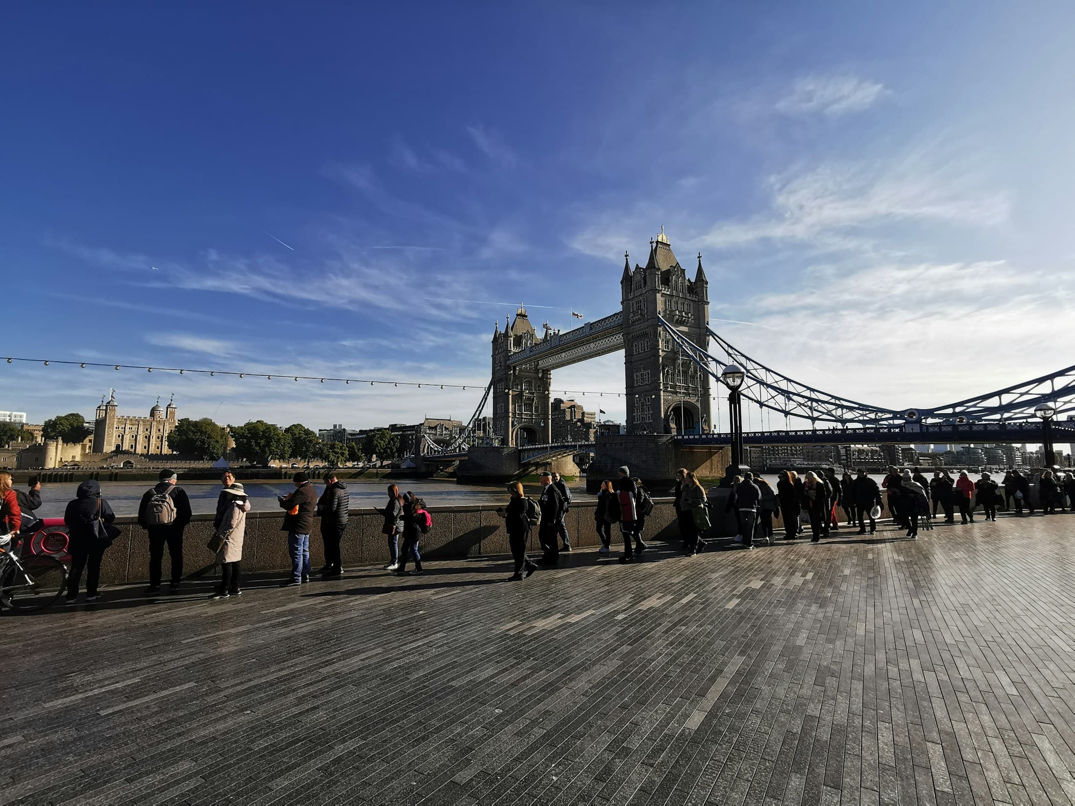 Travelers exploring the Thames riverfront beside Tower Bridge and the Tower of London