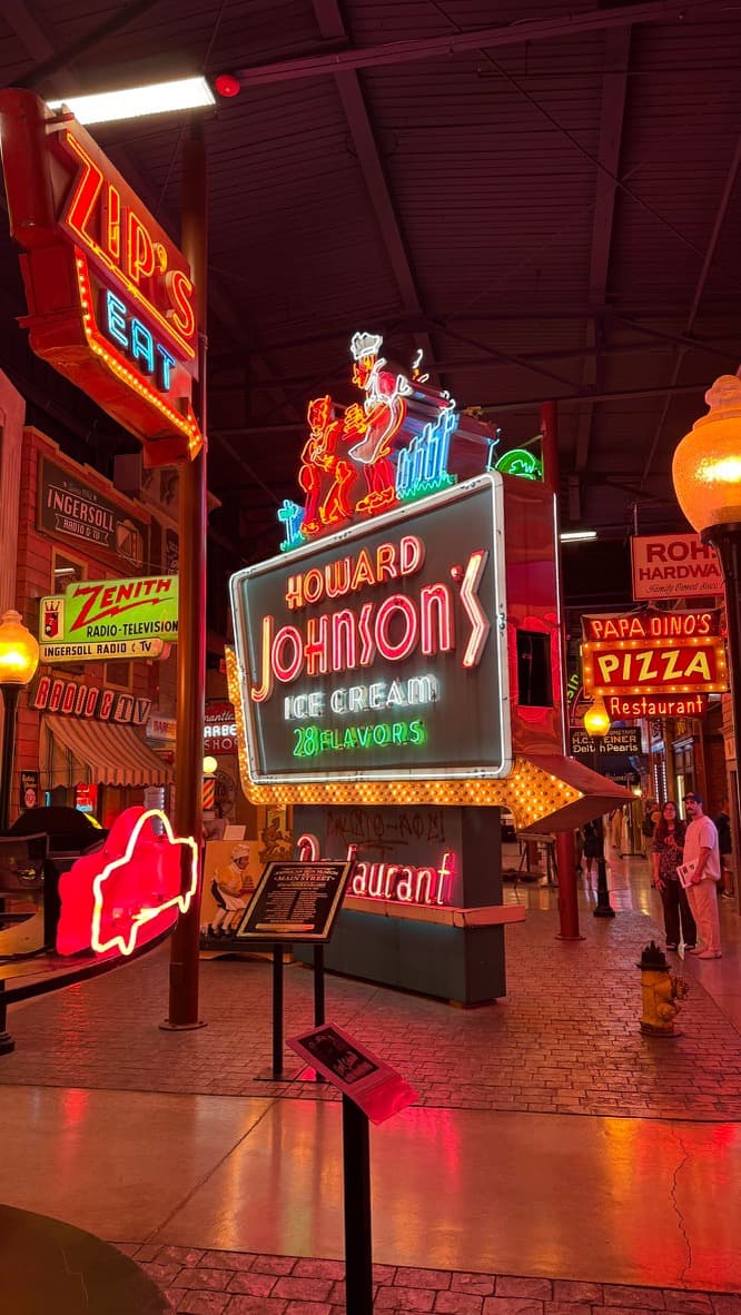 The neon Howard Johnson's Ice Cream sign glowing over the recreated Main Street at the American Sign Museum