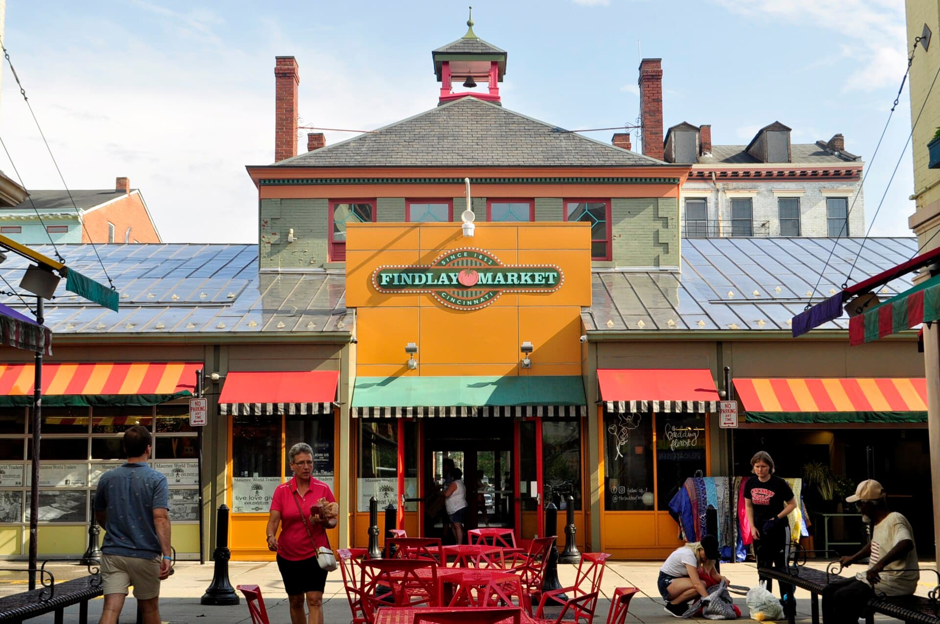 The colorful front entrance of Findlay Market in Cincinnati with visitors at outdoor tables