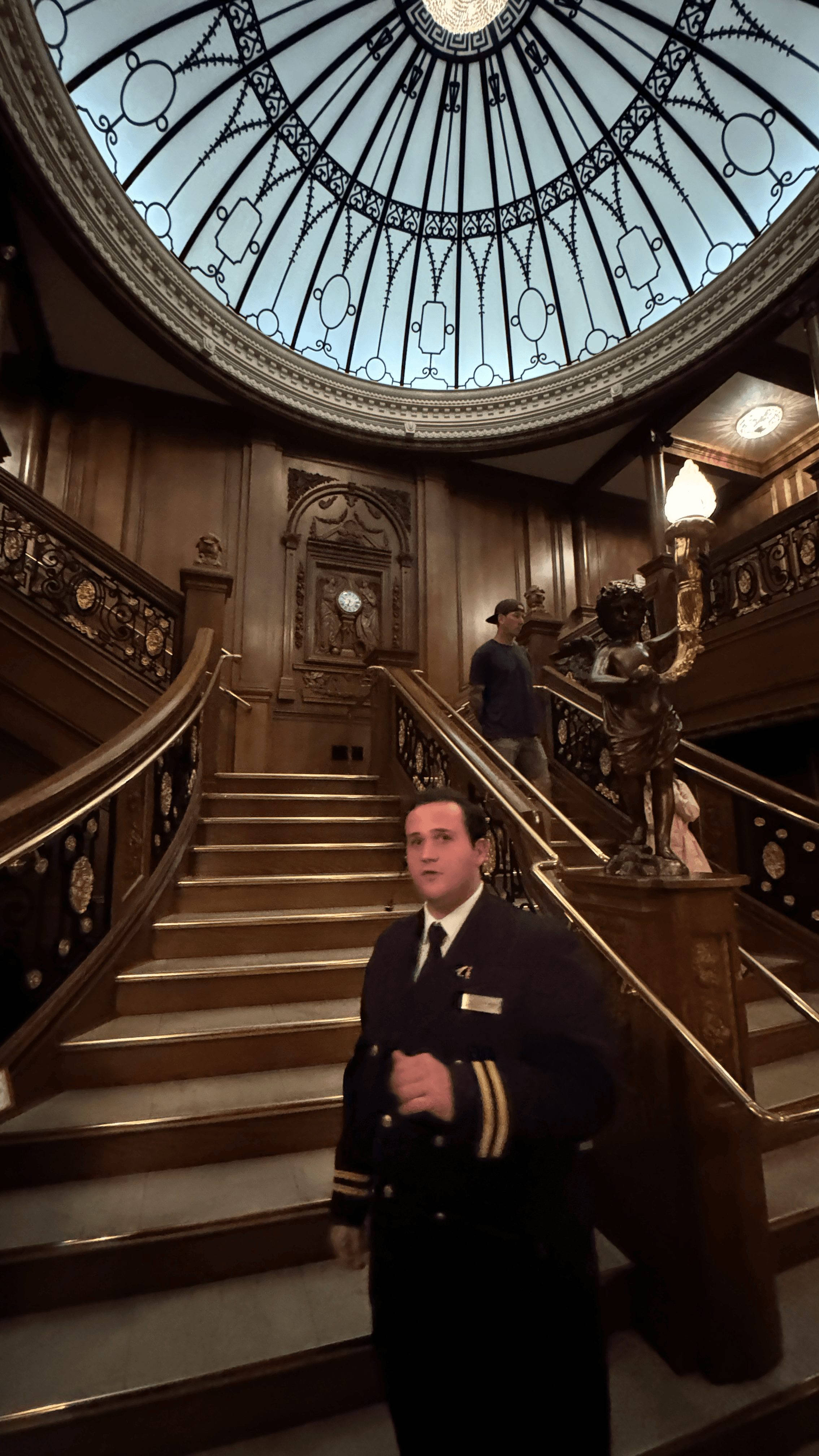 A museum interpreter standing before the recreated Grand Staircase inside the Titanic Museum Attraction
