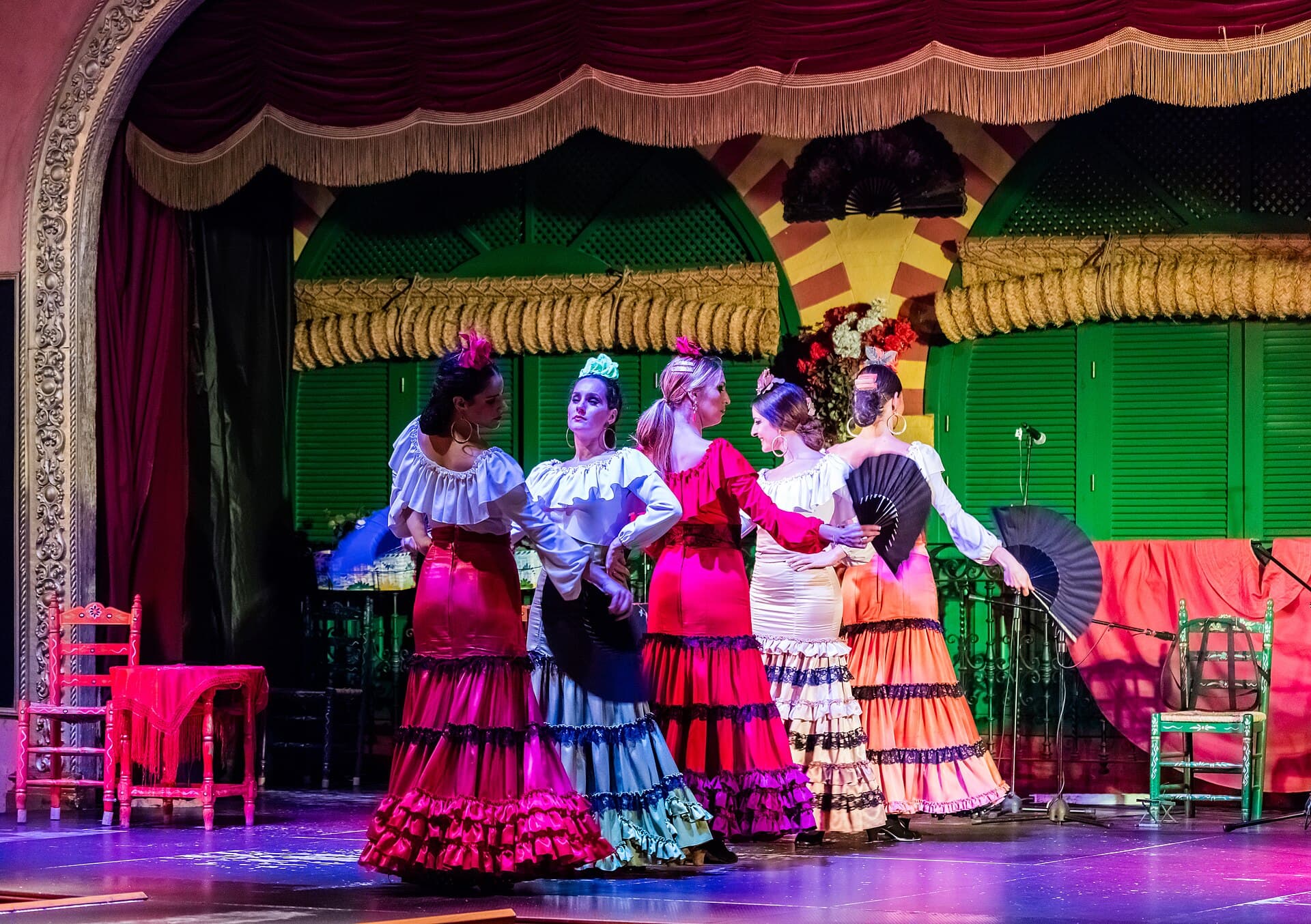 Flamenco dancers in traditional dress performing on a Seville stage