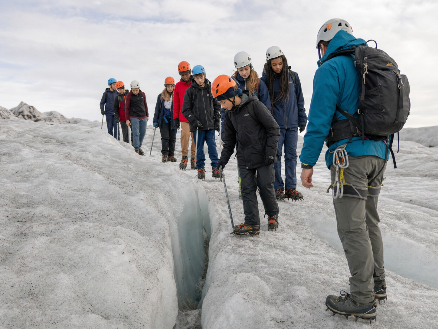 Middle and high school students examining a glacier crevasse with a certified guide