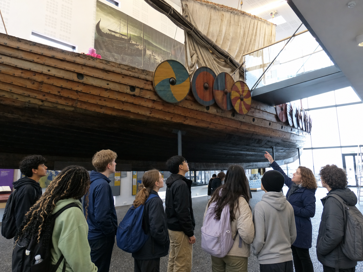 Middle and high school students studying the Íslendingur Viking longship inside Viking World